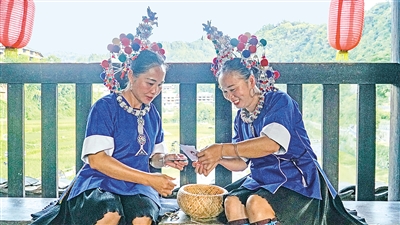     程陽(yáng)橋上，侗族婦女在展示制作侗族刺繡產(chǎn)品。繡品圖案精美、色彩艷麗，成為當(dāng)?shù)靥厣a(chǎn)業(yè)。